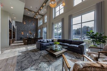 A living room with couches and a coffee table in front of large windows